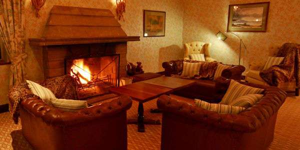 Gasten kunnen genieten bij de openhaard in de lounge van de lodge na het diner. Gasten kunnen genieten bij de openhaard in de lounge van de lodge na het diner.