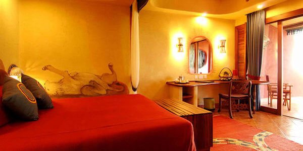 Luxe ingerichte kamers met comfortabele bedden en een zithoek met schuifdeuren naar het terras. Luxe ingerichte kamers met comfortabele bedden en een zithoek met schuifdeuren naar het terras, accommodatie Amboseli Nationaal Park in Kenia
