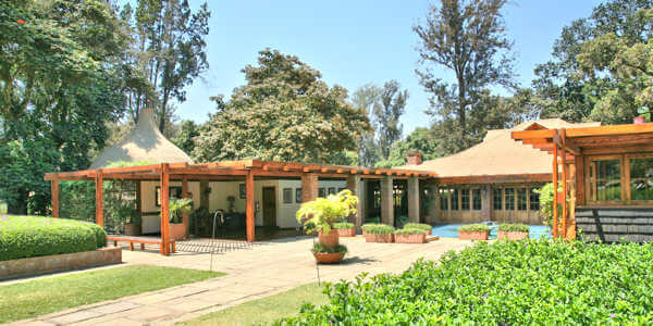 Arusha Coffee Lodge accommodatie entree met vijver, Arusha Nationaal Park in Tanzania Arusha Coffee Lodge accommodatie entree met vijver, Arusha Nationaal Park in Tanzania
