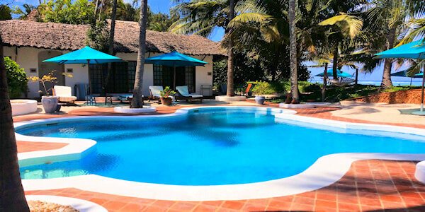 Gasten kunnen relaxen aan het zwembad voor de cottage in de schaduw van parasols. Gasten kunnen relaxen aan het zwembad voor de cottage in de schaduw van parasols, accommodatie Diani Beach in Kenia