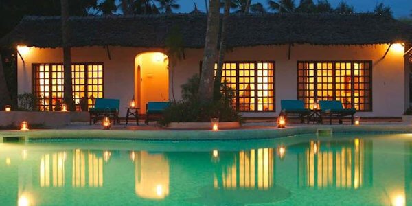 Romantisch dineren rondom het zwembad bij het licht van stormlampen rondom het zwembad. Romantisch dineren rondom het zwembad bij het licht van stormlampen rondom het zwembad, accommodatie Diani Beach in Kenia