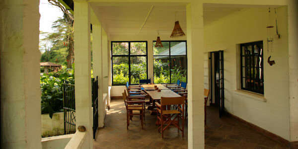 Overdekte veranda met uitzicht op de tuin waar de maaltijden geserveerd worden, accommodatie Naivasha Meer in Kenia