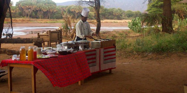 Ontbijt wordt geserveerd aan de oevers van de rivier Ontbijt wordt geserveerd aan de oevers van de rivier, accommodatie Samburu Nationaal Reservaat in Kenia
