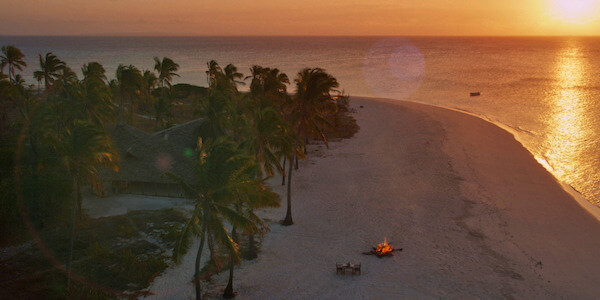 Fanjove eiland geniet van een romantisch culinair diner op het witte zandstrand bij ondergaande zon. Fanjove Eiland in Tanzania