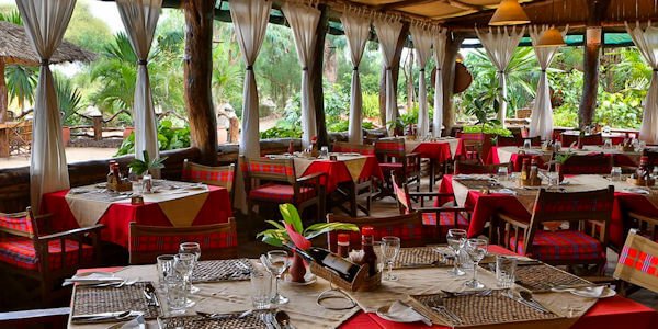 Het restaurant is gedecoreerd met Afrikaanse artefacten en vergezicht op de Mount Kilimanjaro. Het restaurant is gedecoreerd met Afrikaanse artefacten en vergezicht op de Mount Kilimanjaro, accommodatie Amboseli Nationaal Park in Kenia