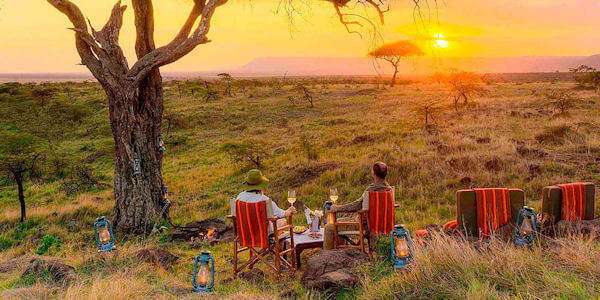 Geniet met een cocktail van een mooie zonsondergang over de savannes van de Masai Mara Geniet met een cocktail van een mooie zonsondergang over de savannes van de Masai Mara