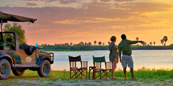 Genieten van een zonsondergang met een cocktail in het Nyerere nationaal park Genieten van een zonsondergang met een cocktail in het Nyerere nationaal park