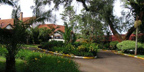 Entree van The Outspan Hotel van uit Nyeri omgeven door een oude inheemse tuin. Entree van The Outspan Hotel van uit Nyeri omgeven door een oude inheemse tuin.