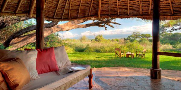 Geniet van het uitzicht vanaf de veranda op de Kilimanjaro in het Amboseli Nationaal Park. Tortilis Safari Camp geniet van het uitzicht vanaf de veranda op de kilimanjaro in het amboseli nationaal park. Amboseli Nationaal Park in Kenia